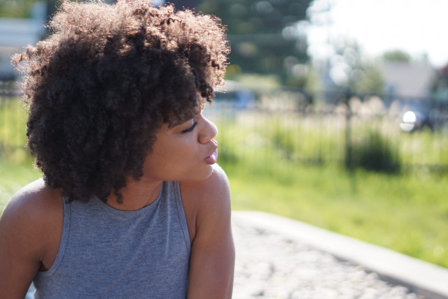 Image of a Black woman looking to her left and into the distance. This photo is representative of how those going through therapy for homicide survivors in Baltimore, MD are able to look forward after working with a trauma therapist in Pikesville, MD. | 21208