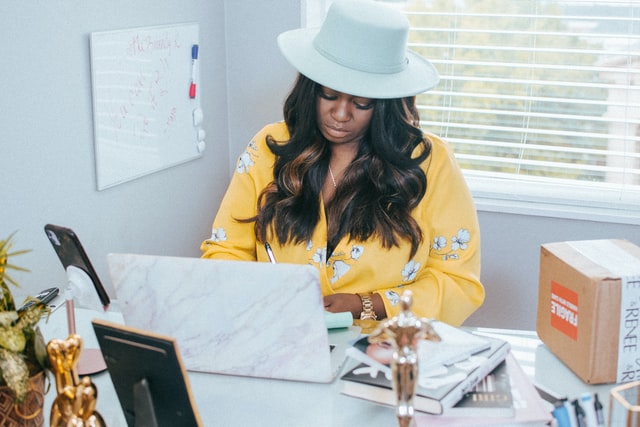 A black career woman works in her office representing the struggle black woman frequently face as they deal with Superwoman Syndrome in Baltimore, MD.