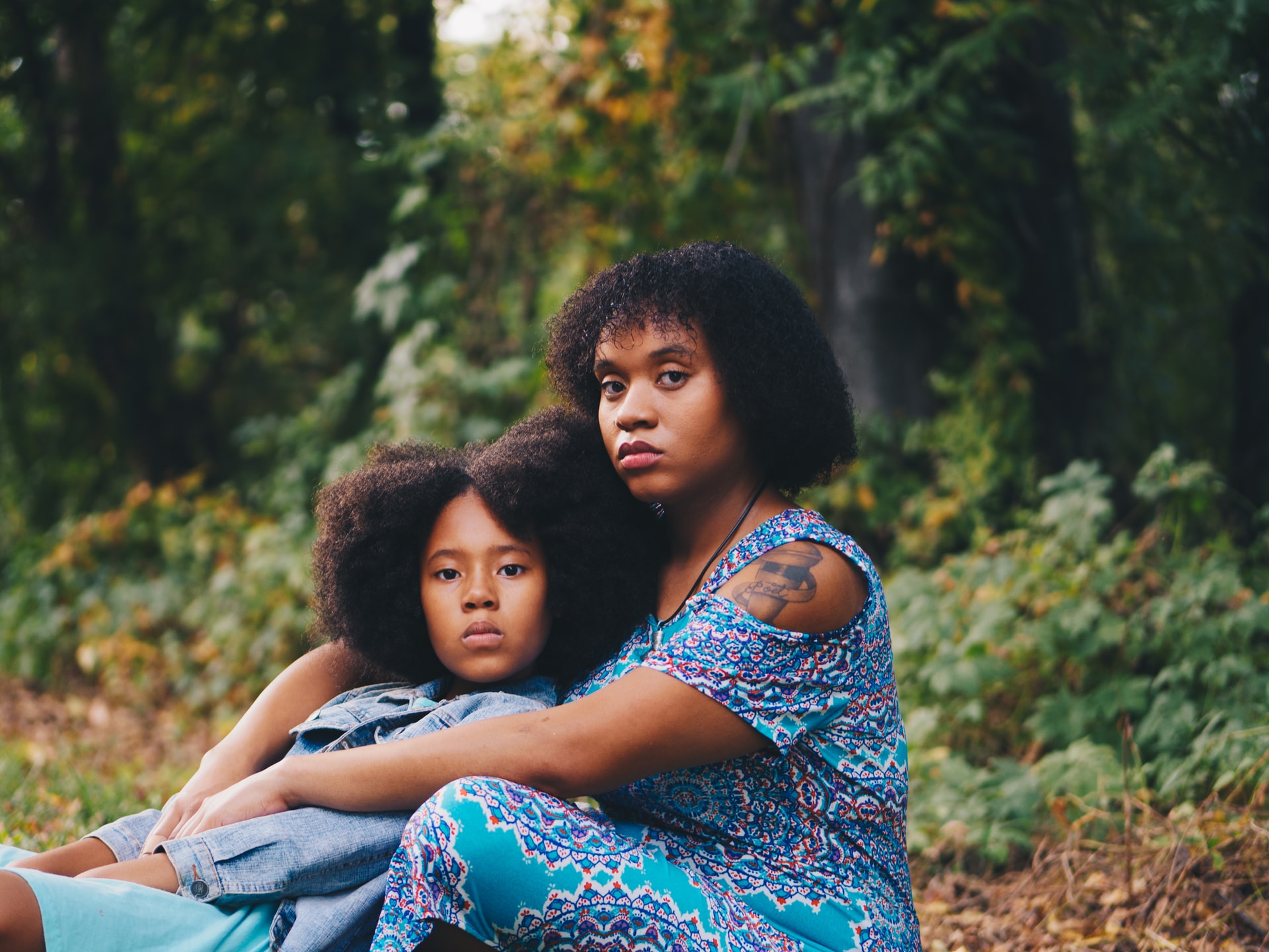 Two Black women lean on each other for support as they deal with their own personal traumas. Learn to overcome trauma in EMDR Therapy in Baltimore, MD.