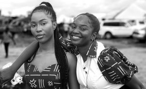 Two young Black women with their arms around each other smile at the camera representing the need for love and support to overcome trauma. EMDR Therapy in Baltimore, MD can help break free of the trauma cycle.