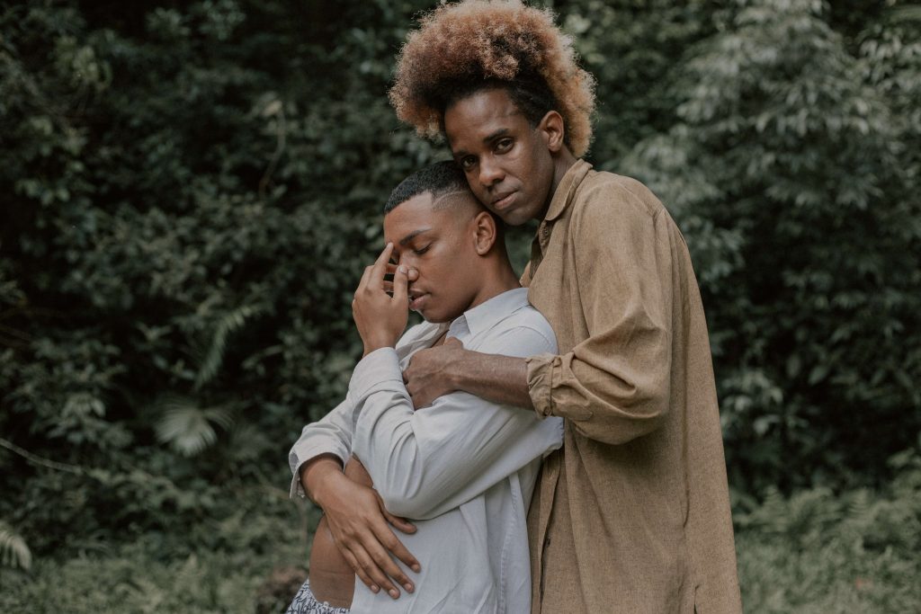 A gay black couple embrace as one of them deals with the impact of trauma. EMDR Therapy in Baltimore, MD is an effective tool to overcome and process trauma. 