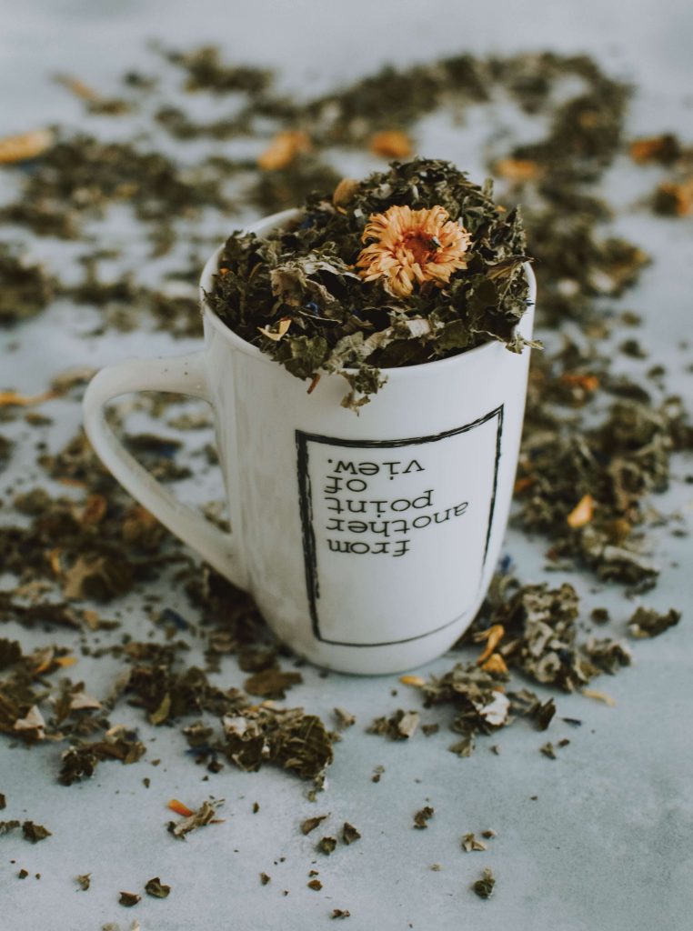 A cup with dried herbs in it represents using adaptogens as part of mind-body medicine in Baltimore, MD.