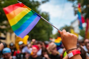 A close up of a hand holding up a pride flag in a pride parade. Learn how an LGBTQ therapist in Pikesville, MD by searching for LGBTQ counseling in Pikesville, MD. Search for a trauma therapist in Baltimore, MD to learn more of healing from trauma.